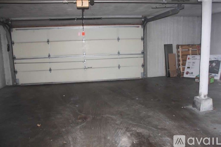 A large garage with a white door and a concrete floor.