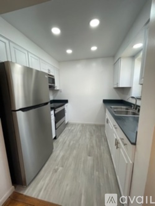 A kitchen with stainless steel appliances and white cabinets.