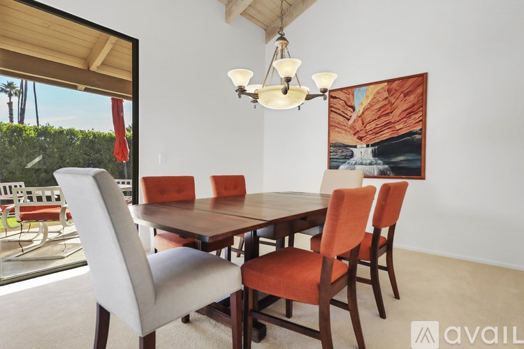 A dining room with a wooden table and chairs.