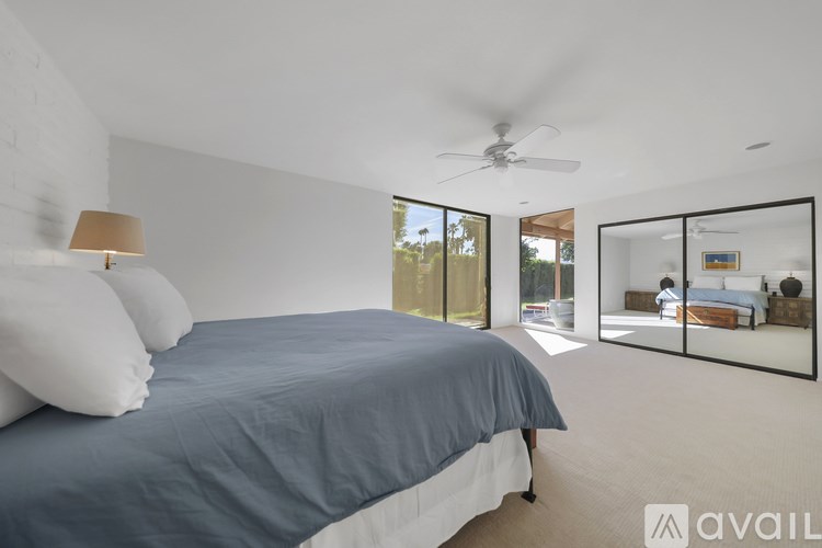 A bedroom with a large bed and a ceiling fan.