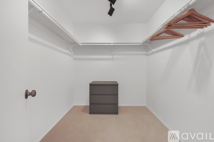 A room with a ceiling fan, a brown dresser, and a wall-mounted coat rack.