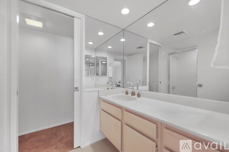 A bathroom with a white sink and a large mirror.