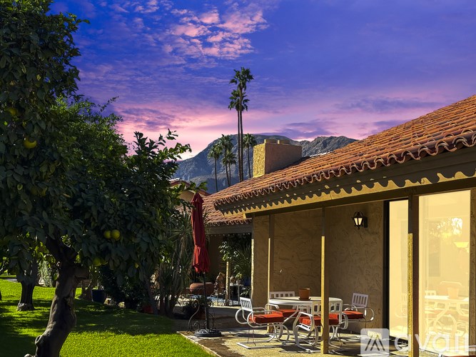 A patio with chairs and a table is set up outside a house.