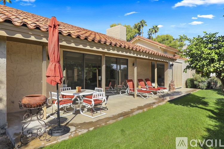 A patio with a table and chairs is set up outside a house.