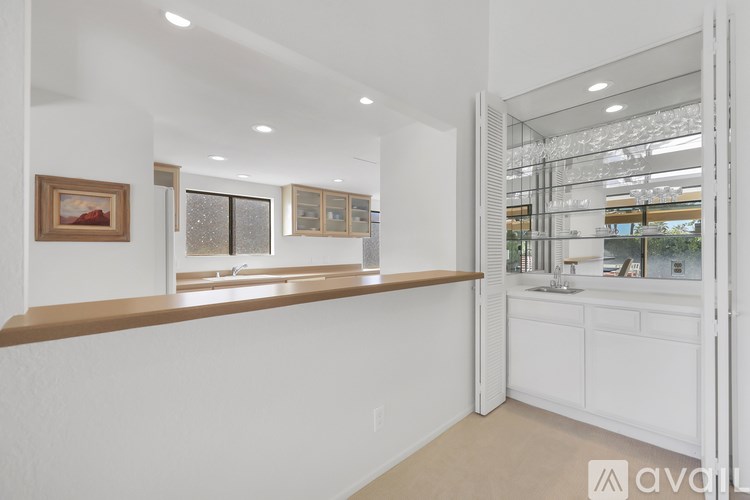 A kitchen with white cabinets and a brown countertop.