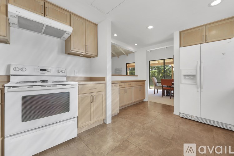 A kitchen with white appliances and wooden cabinets.