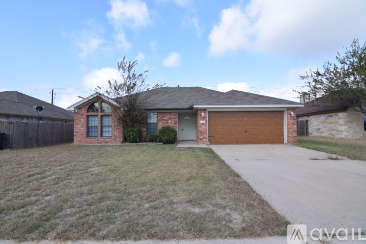 A house with a brown garage door and a brick facade.