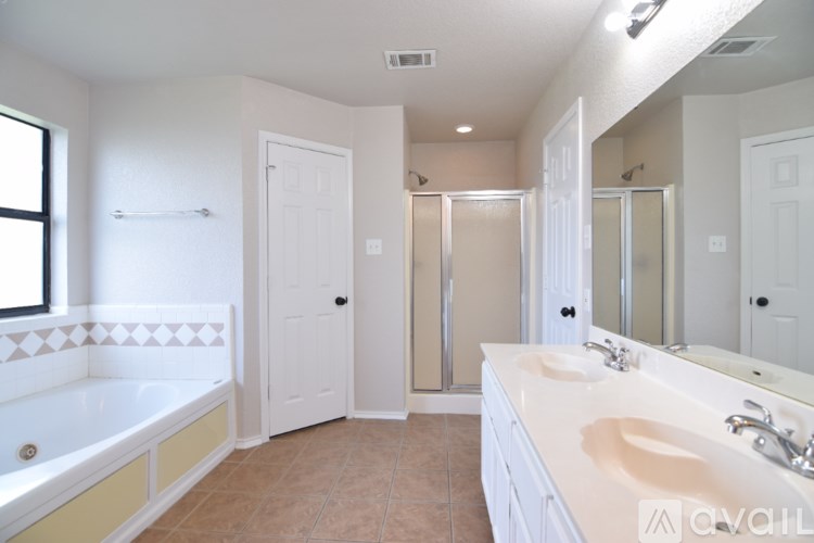 A bathroom with a tub, sink, and mirror.