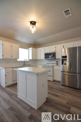 A kitchen with white cabinets and a wooden island.
