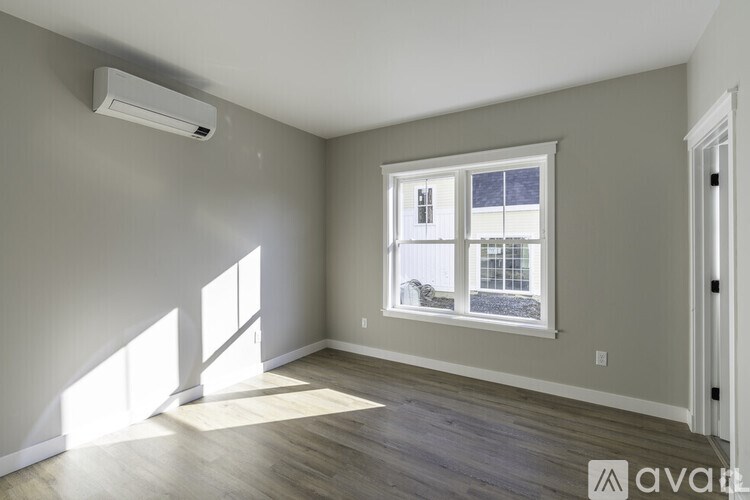 A room with a window and a wall-mounted air conditioner.