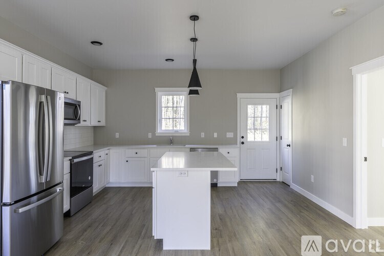 A kitchen with white cabinets and a white island.