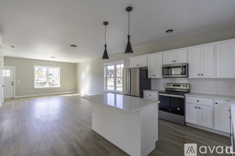 A kitchen with white cabinets and a large island.
