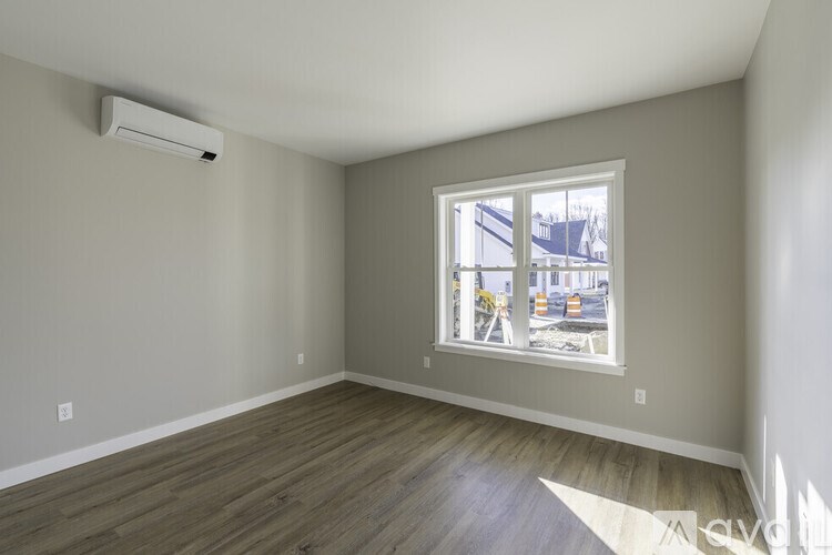 A room with a window showing a street view outside.