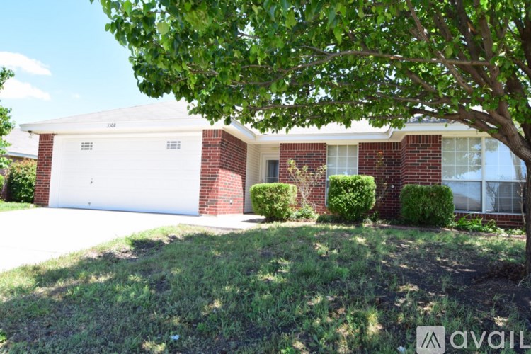 A house with a white garage door and a tree in front.