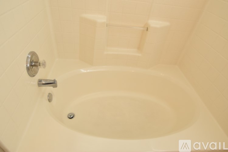 A white bathtub with a silver faucet and a silver handle.