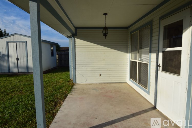 A patio area of a house with a white door and a hanging light fixture.