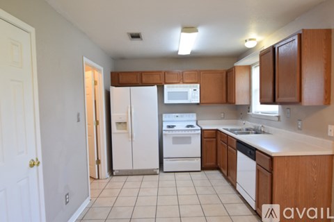 A kitchen with white appliances and wooden cabinets.