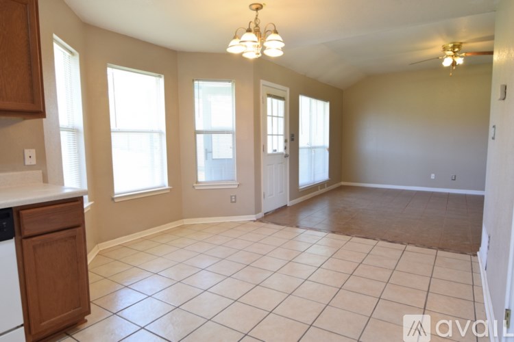A room with a kitchen area and a large empty space.