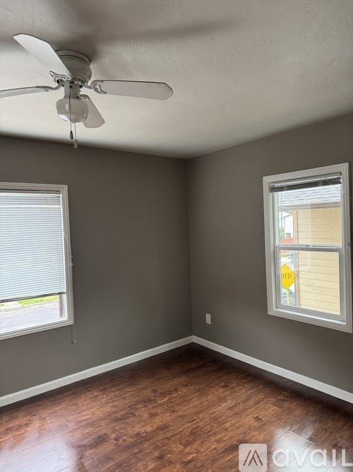A room with a ceiling fan and a window with blinds.