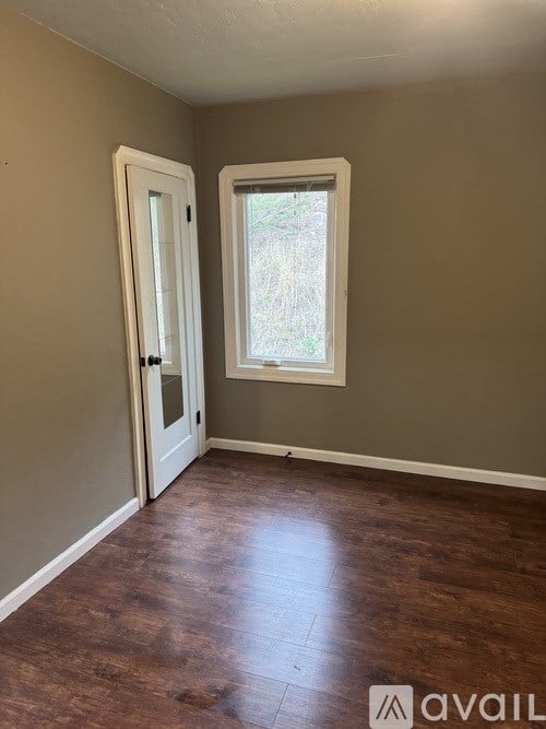 A room with a brown floor and a white door.