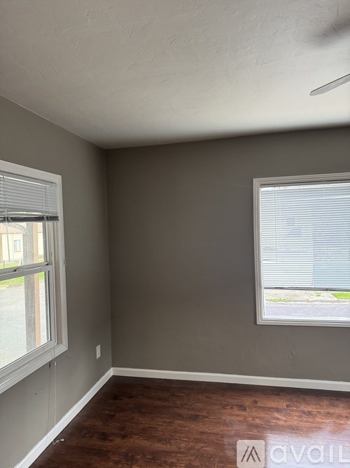 A room with a window and a wooden floor.