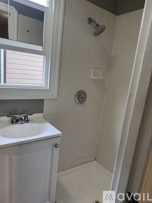 A bathroom with a white sink and a shower.