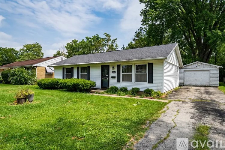 A white house with a grey roof and a garage door.