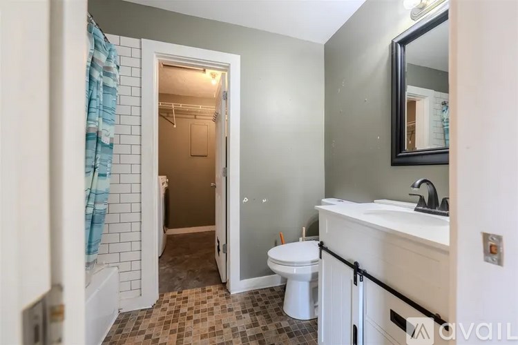 A bathroom with a toilet, sink, and shower.