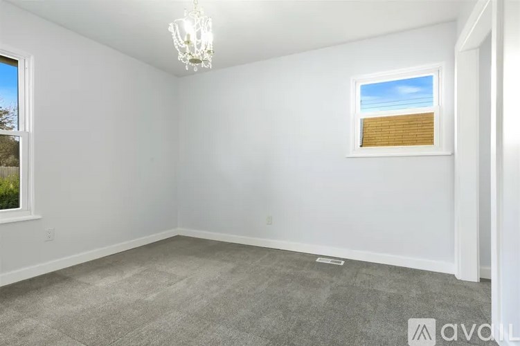 A room with a window and a chandelier.