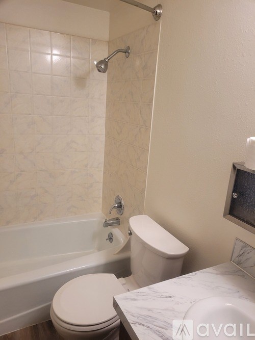 A bathroom with a tub, toilet and sink.