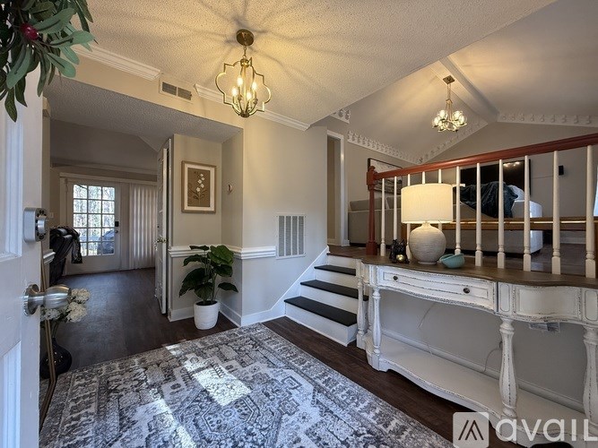 A well-lit room with a staircase and a desk.