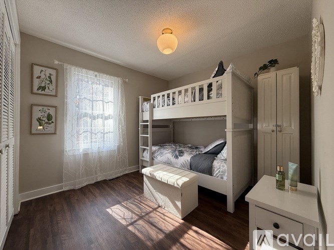 A bedroom with a bunk bed and a window with curtains.