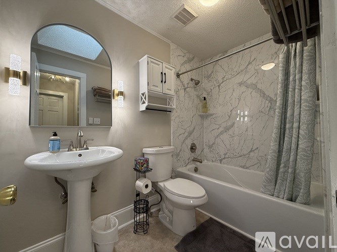 A bathroom with a white sink, toilet, and bathtub.