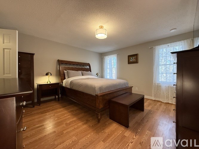 A bedroom with a large bed and wooden floors.