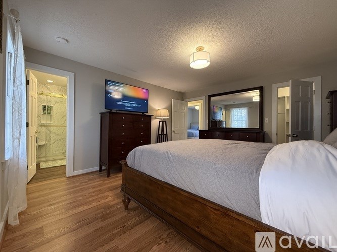 A bedroom with a bed, dresser, and mirror.