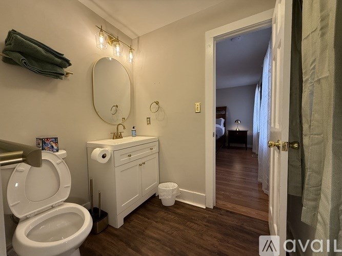 A bathroom with a toilet, sink, and mirror.
