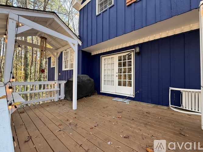 A blue house with a white porch and a white bench.