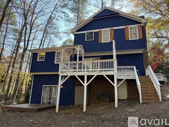 A blue house with a white porch and stairs leading up to the door.