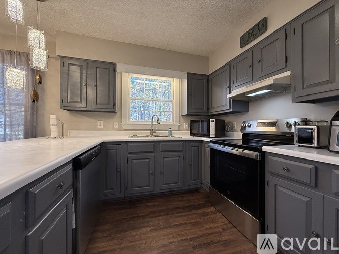 A kitchen with dark grey cabinets and a white countertop.