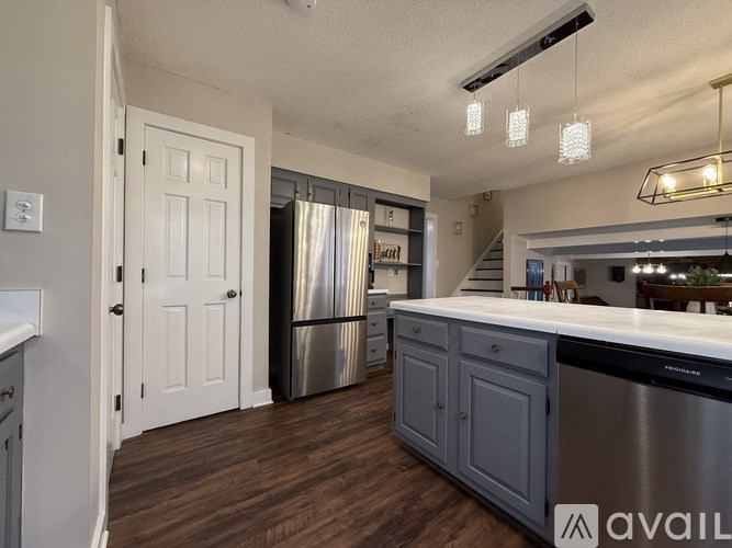 A kitchen with a white door and a stainless steel refrigerator.