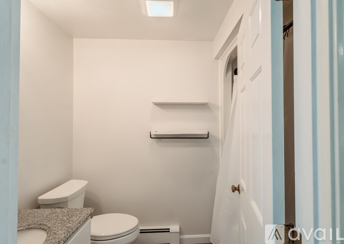 A small bathroom with a toilet and a towel rack.