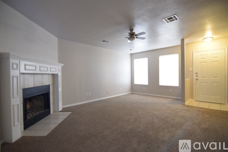 A spacious living room with a fireplace and a carpeted floor.