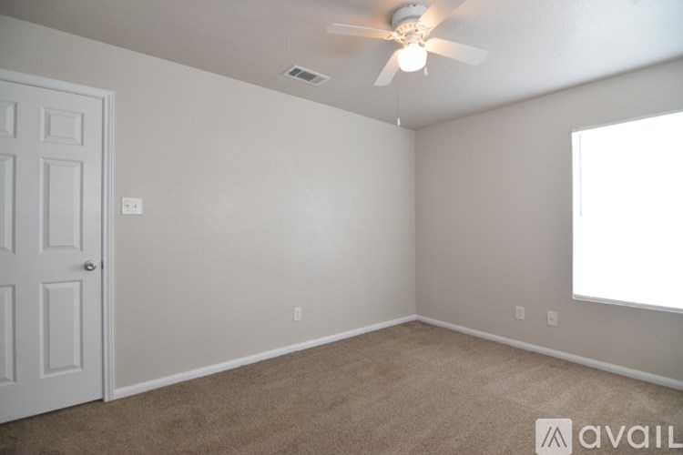 A room with a ceiling fan and a door.