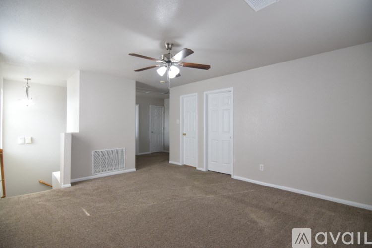 A room with a ceiling fan and carpeted floor.