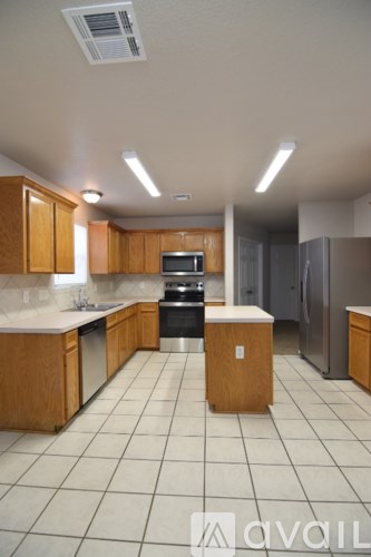 A kitchen with wooden cabinets and a white tile floor.