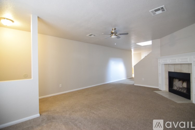 A living room with a fireplace and a ceiling fan.