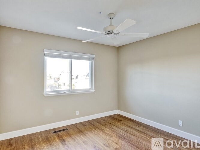 A room with a ceiling fan and a window.