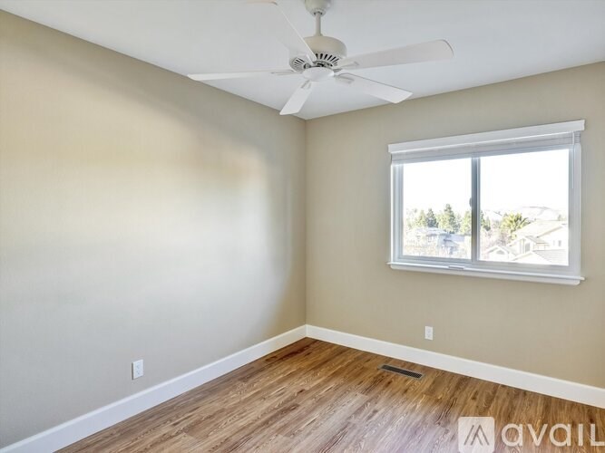 A room with a ceiling fan and a window.