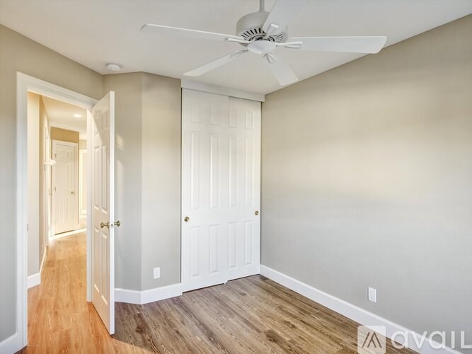 A room with a ceiling fan and two doors.