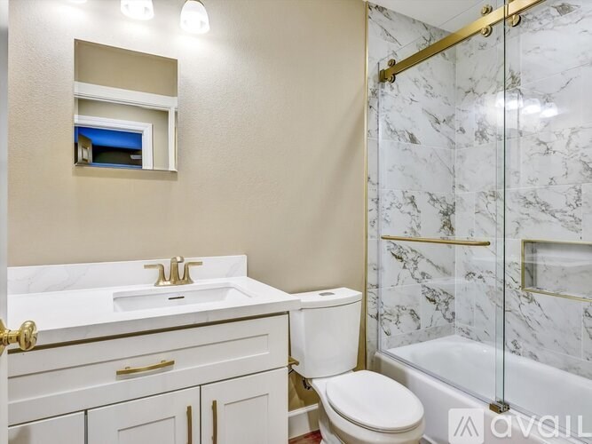 A white bathroom with a marble shower.